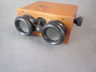 une petite boîte en bois sur laquelle sont posées deux jumelles