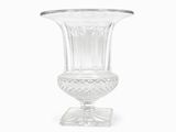 un vase en verre transparent posé sur un socle, sur fond blanc