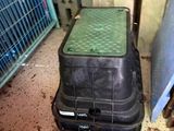 a black suitcase sitting on the floor next to a blue crate