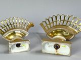 pair of silver and gold plated candlestick holders with a crown on top