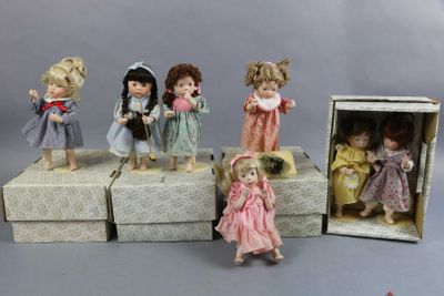 five dolls that are sitting in a box on a table