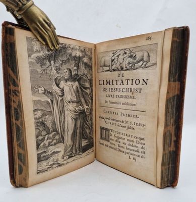 an open book with a hand holding a glove on top of it