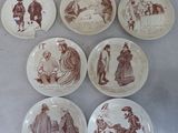 plusieurs assiettes ornées de dessins représentant des personnes et des animaux, posées sur une table