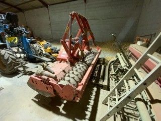 une photo d'un tracteur dans un garage, équipé d'un chargeur