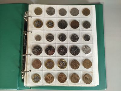 a green binder with a lot of coins on it