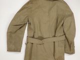 the back of a tan jacket with a belt on a white background