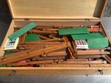 une boîte en bois contenant des rails de train en bois et une calculatrice
