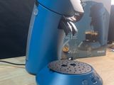 une cafetière bleue posée sur une table à côté d'une boîte de café