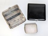 two silver and black metal cases sitting on top of a white table