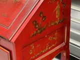 a red desk with a red top and gold decorations on it