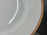 two white plates with gold trim are stacked on top of each other