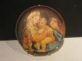 a plate with a painting of a woman holding a child