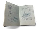 un passeport ouvert, comportant des tampons, posé sur une surface blanche