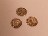three gold coins sitting on top of a table next to each other