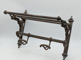 un porte-serviettes ancien en fonte, orné d'un motif décoratif
