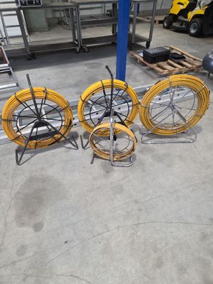 trois tuyaux jaunes posés sur un support métallique dans un garage