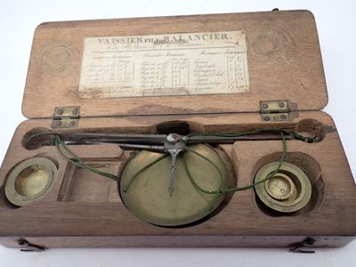 une boîte en bois contenant une balance et une horloge