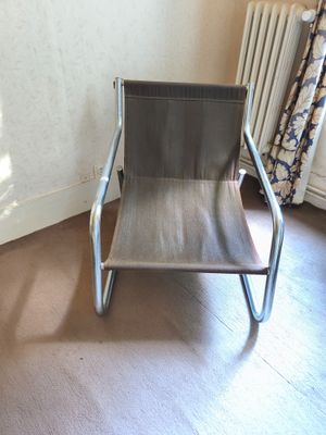a chair in the corner of a room with a radiator