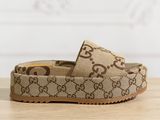 un gros plan sur une paire de Gucci posée sur une surface en bois
