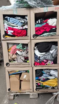 un chariot sur lequel sont empilées de nombreuses boîtes de vêtements
