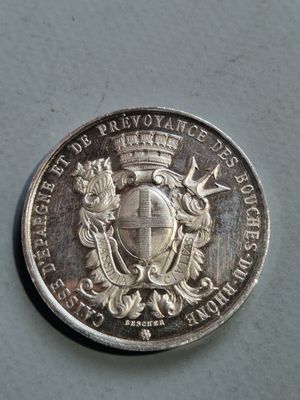 un gros plan d'une pièce d'argent sur laquelle figure un blason