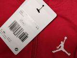 the back of a red jacket with a white jordan logo on it