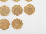 six different types of gold coins on a white surface