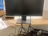 a computer desk with a monitor, keyboard, mouse, and other electronics