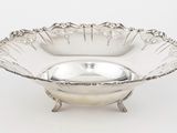un plat ancien en argent dont le bol a la forme d'une fleur