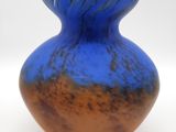 a blue and brown vase sitting on a white surface