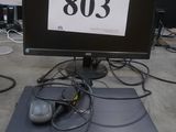 un écran d'ordinateur posé sur un bureau, avec une souris dessus