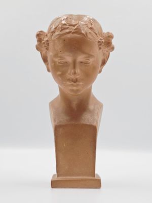 sculpture d'une tête de femme sur une base en bois