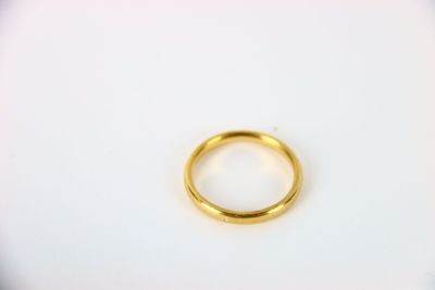 gros plan d'une bague en or sur une surface blanche