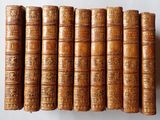 plusieurs vieux livres sont alignés sur une surface blanche