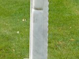 a statue of a man holding a sword in a grassy field