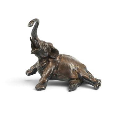 statue of an elephant laying down on its back with its trunk raised