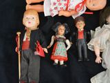 a lot of dolls that are laying on a black surface