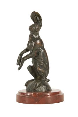 statue représentant un lapin debout sur ses pattes arrière, posée sur un socle en bois