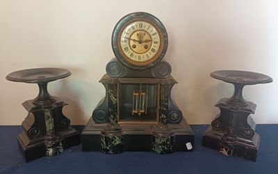 trois horloges posées les unes à côté des autres sur une table bleue