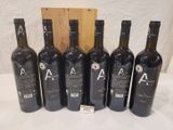 six bottles of wine are lined up in a row on a table