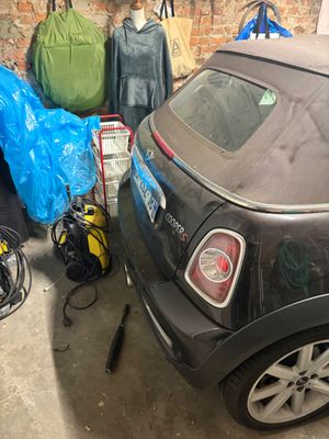 une voiture garée dans un garage à côté d'une pile de bagages