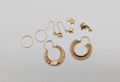 une paire de boucles d'oreilles créoles en or et une paire de boucles d'oreilles en forme d'étoile