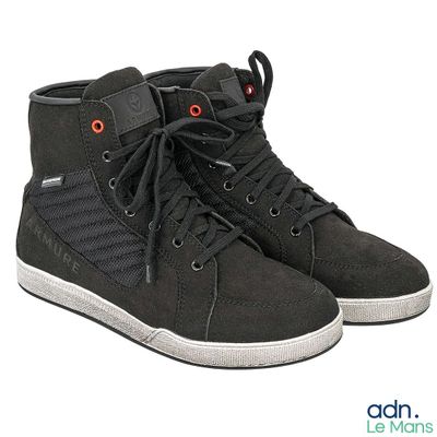 une paire de chaussures noires avec des yeux rouges sur fond blanc