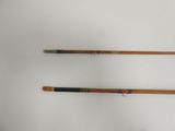 two old fishing rods sitting on top of a table next to each other