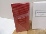 two boxes of perfume sitting on top of a wooden table next to a box of perfume