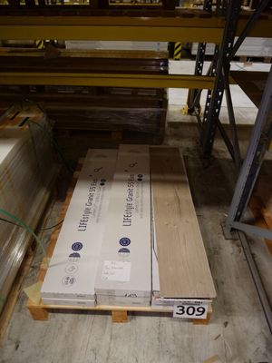 many boxes of wood sitting on pallets in a warehouse
