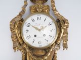 a gold clock that is hanging on the wall