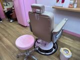 une chaise rose et un tabouret rose dans une pièce