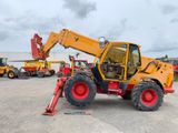 the back end of a yellow and red tractor parked in a parking lot