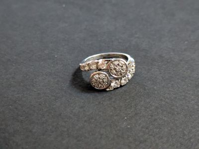 silver ring with white stones on a black surface